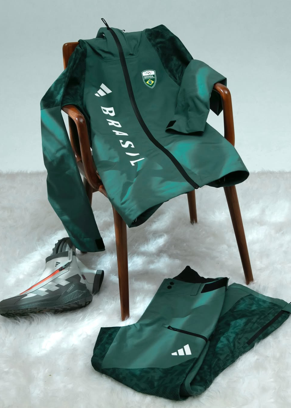 Conjunto esportivo verde escuro com jaqueta e calça de tecido técnico, detalhes em preto e branco.