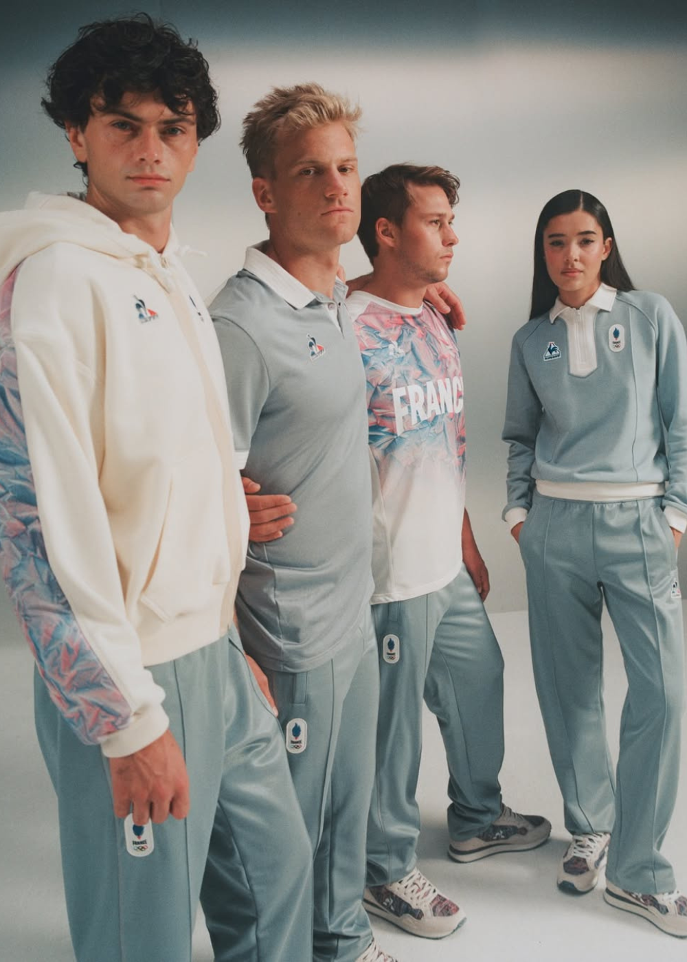 Quatro modelos posam com looks esportivos em tons pastel azul e branco.