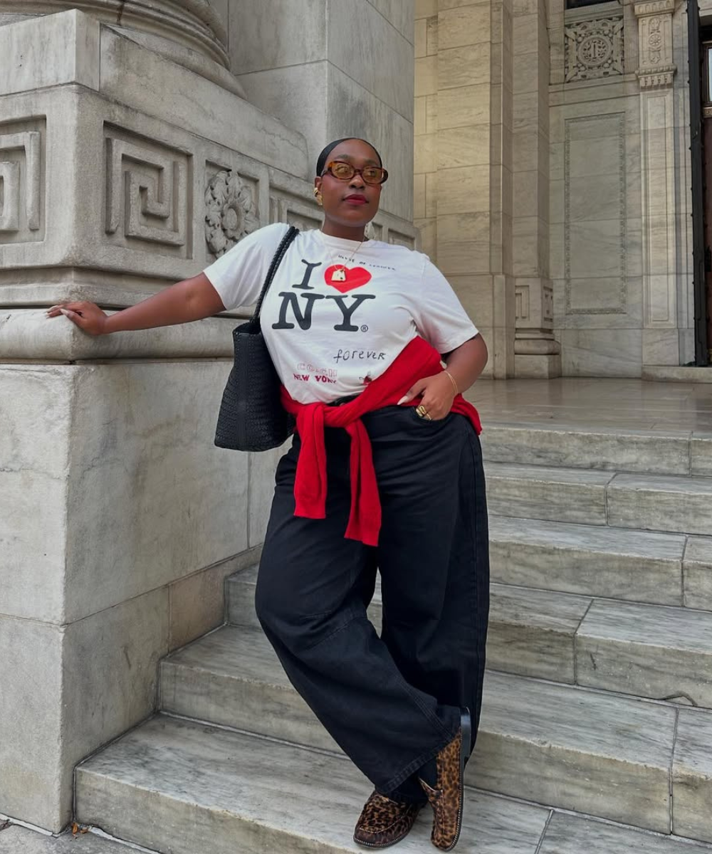 Modelo posa com calça baggy preta, camiseta branca I ♥ NY.