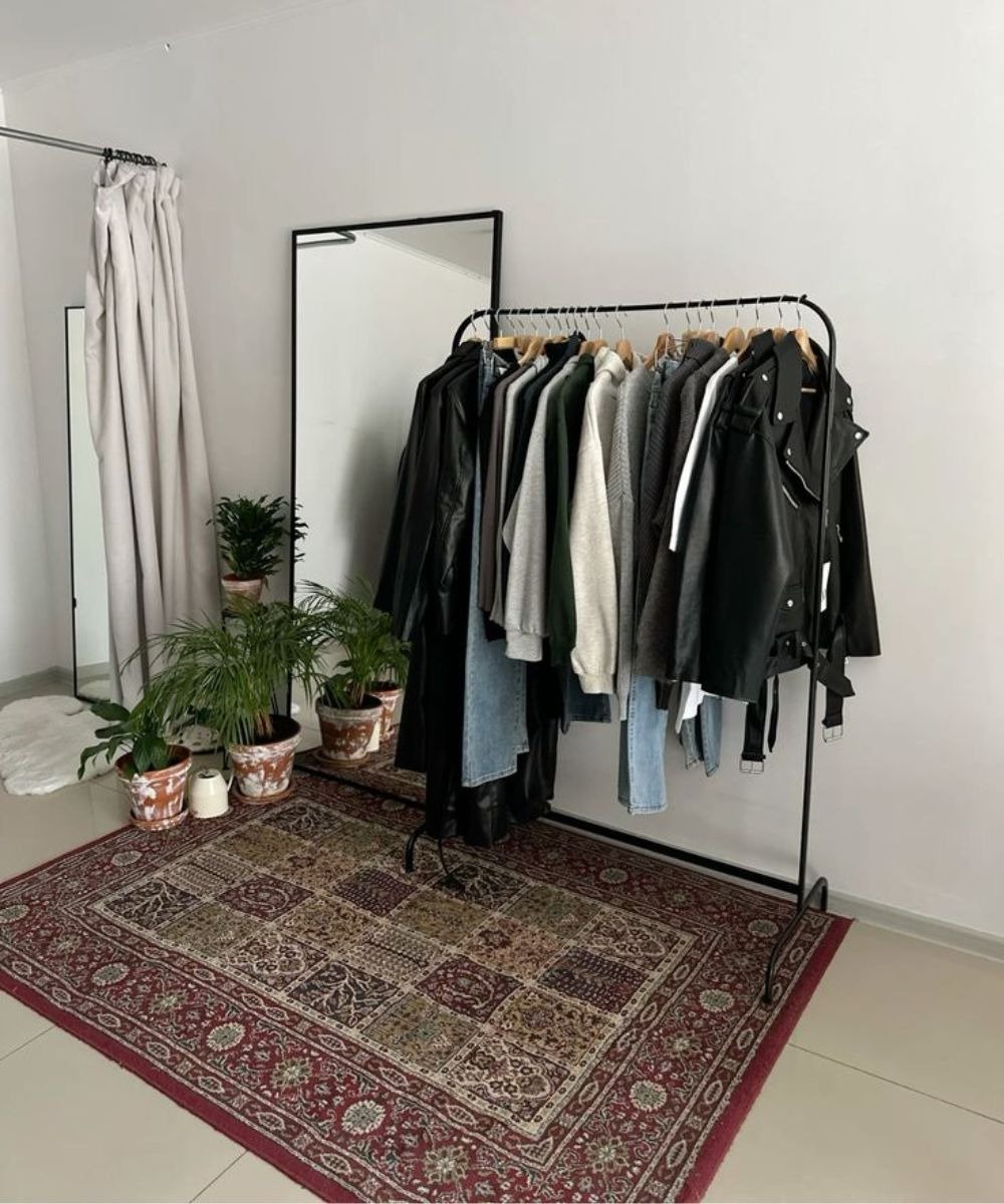 Armário cápsula com jaquetas de couro, tricôs e jeans em preto, cinza e off-white.