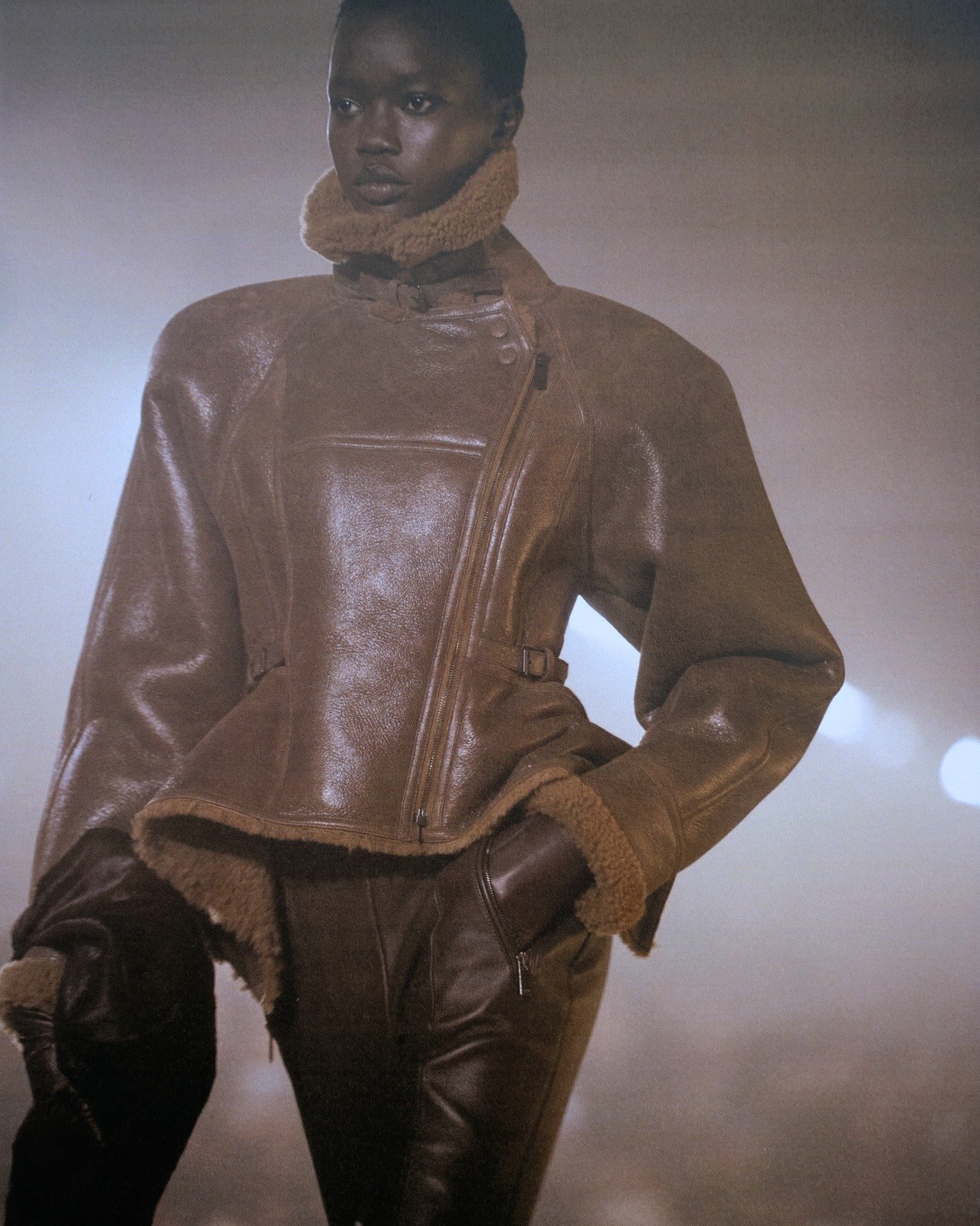 Modelo posa com jaqueta aviador marrom de couro e shearling, na primeira coleção de Antonin Tron para Balmain.