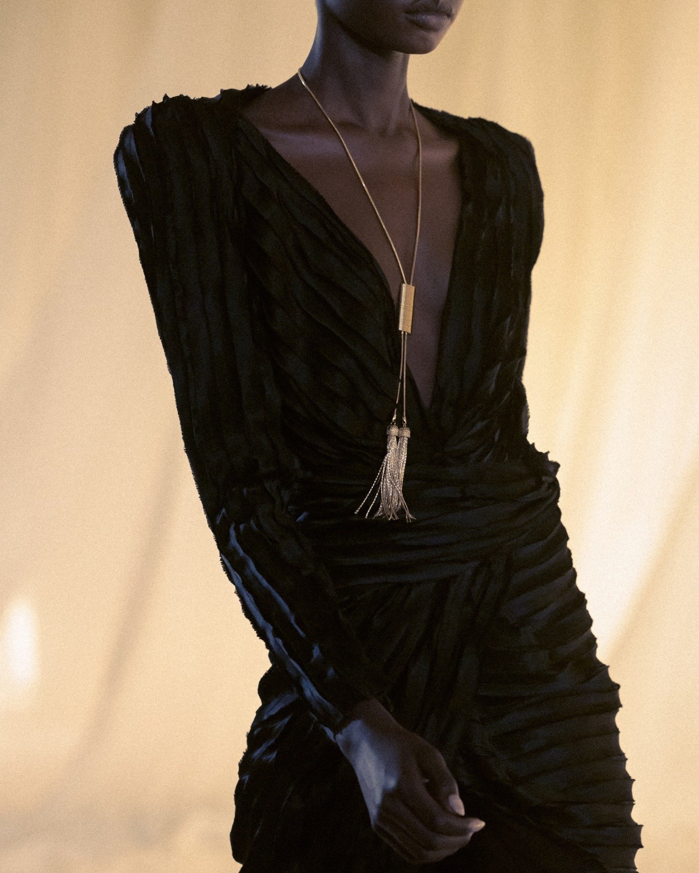 Antonin Tron destaca vestido preto de veludo com textura em camadas e decote profundo, realçado por colar longo dourado