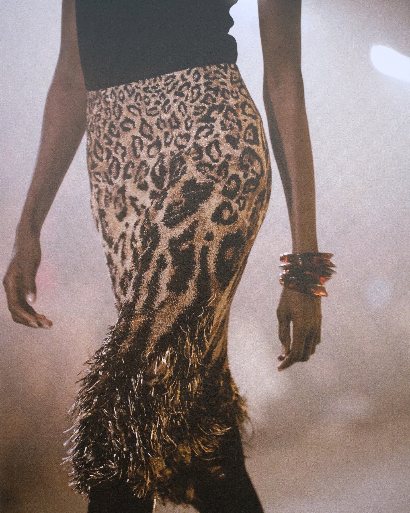 Antonin Tron destaca saia lápis com estampa animal e acabamento em franjas metálicas, combinada a pulseiras largas