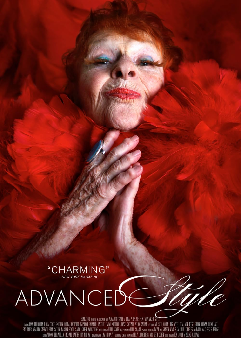 Idosa posa com expressão confiante e elegante, vestindo gola de penas vermelhas vibrantes, em documentários de moda.