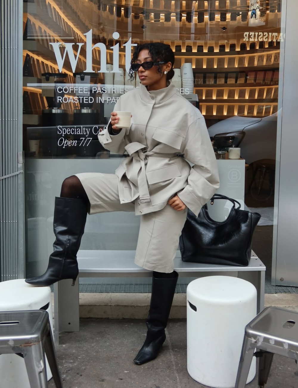 Looks com meia-calça: modelo posa de bege e preto com jaqueta ampla, bermuda e bota alta.