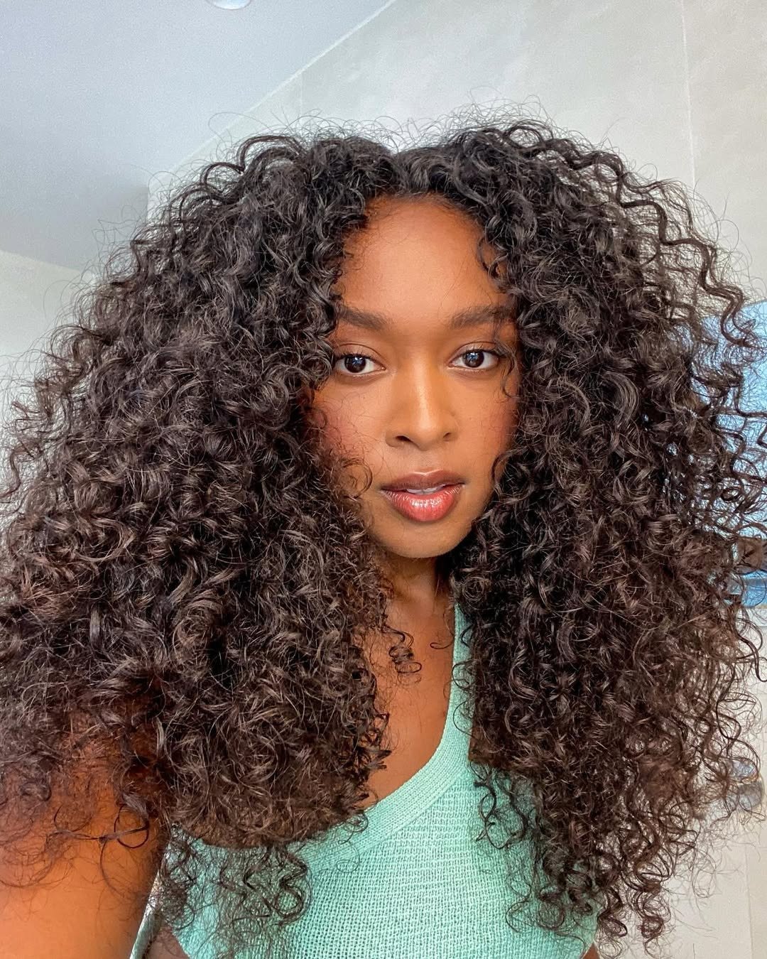 influenciadora posando para a câmera representando os melhores cremes de nutrição para cabelos cacheados