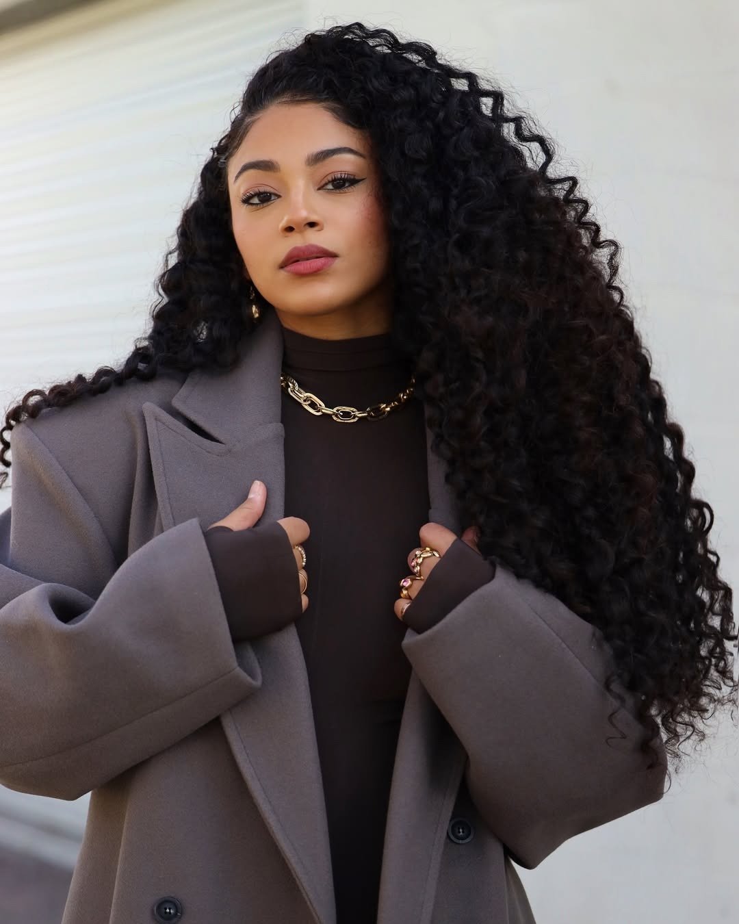 influenciadora posando para a câmera representando os melhores cremes de nutrição para cabelos cacheados