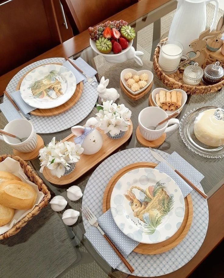 Mesa posta para Páscoa com louça de coelho, sousplats de madeira, tons pastel, flores brancas e clima acolhedor.