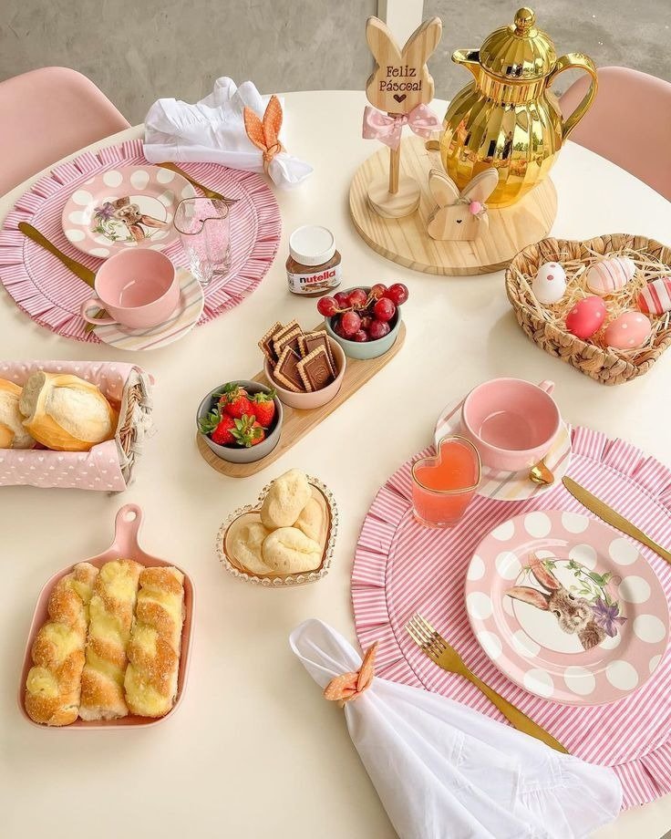 Mesa posta para Páscoa em rosa e dourado com louça de coelho, guardanapos com orelhas, doces e clima delicado.