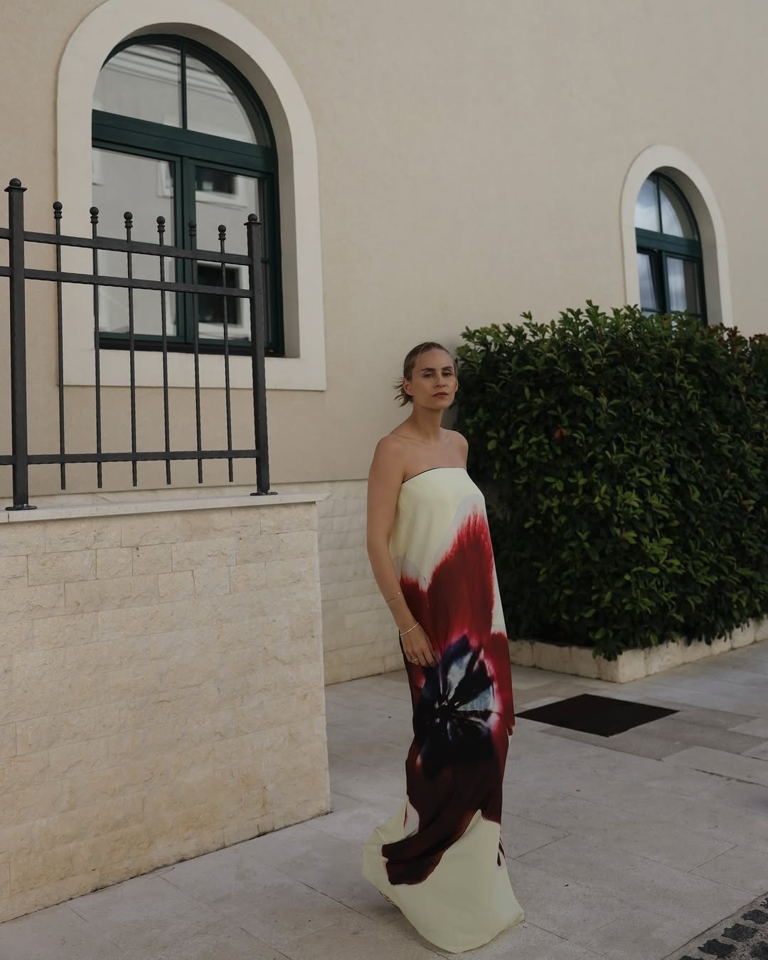 Modelo posa com vestido tendência 2026 justo de alças finas, estampa vibrante em tons de rosa e vermelho, clima leve e