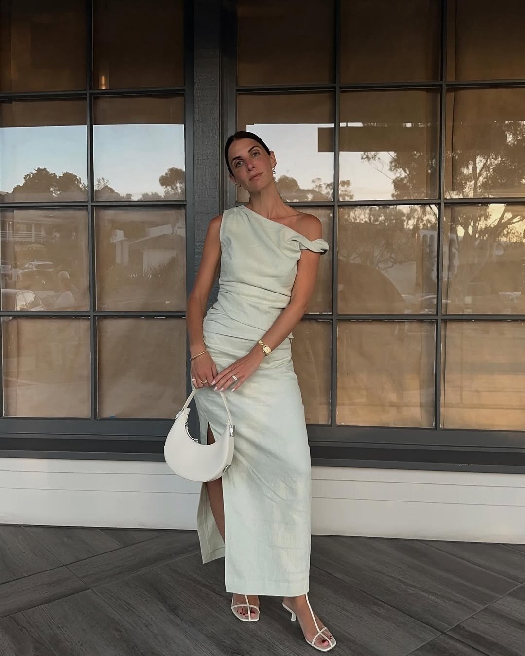 Vestido tendência 2026 em modelagem reta com fenda e ombro único, tecido leve off-white, look minimalista e elegante com