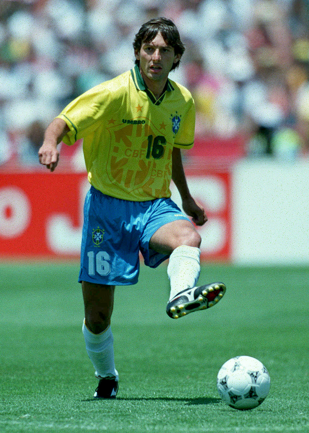 Camisas do Brasil em campo: jogador corre com camisa amarela, short azul e energia competitiva.