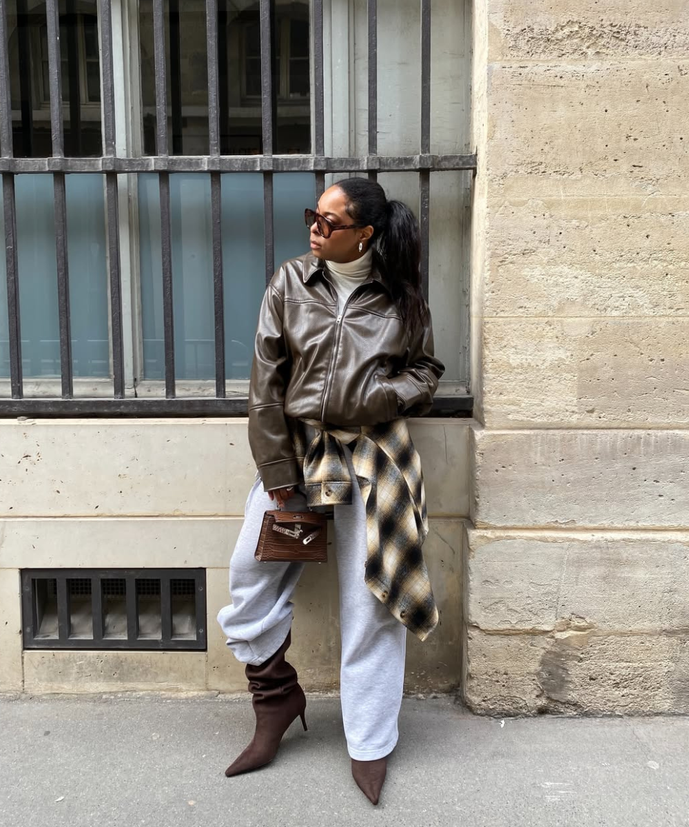 Looks com calça de moletom: modelo posa com jaqueta marrom, gola alta e bota de salto em clima urbano sofisticado.