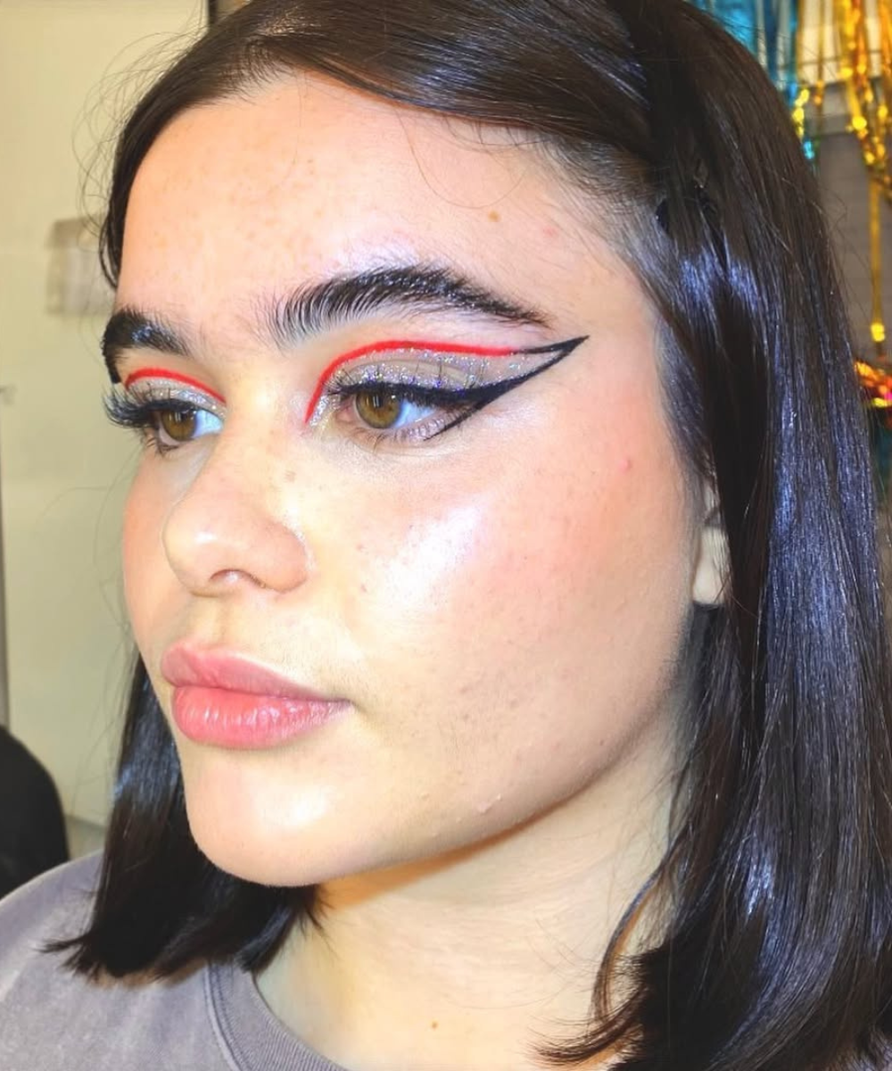Maquiagens de Euphoria: a personagem Kat de Euphoria (Barbie Ferreira) usa delineado gráfico preto e laranja com glitter. 