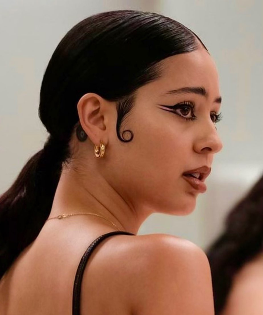 Maquiagens de Euphoria: a personagem Maddy de Euphoria (Alexa Demie) usa delineado gráfico laranja.