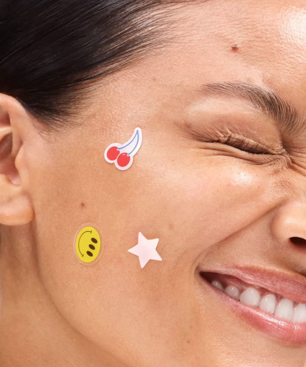 Protocolo de beleza em close de rosto sorridente com pele luminosa e adesivos coloridos, clima leve e divertido