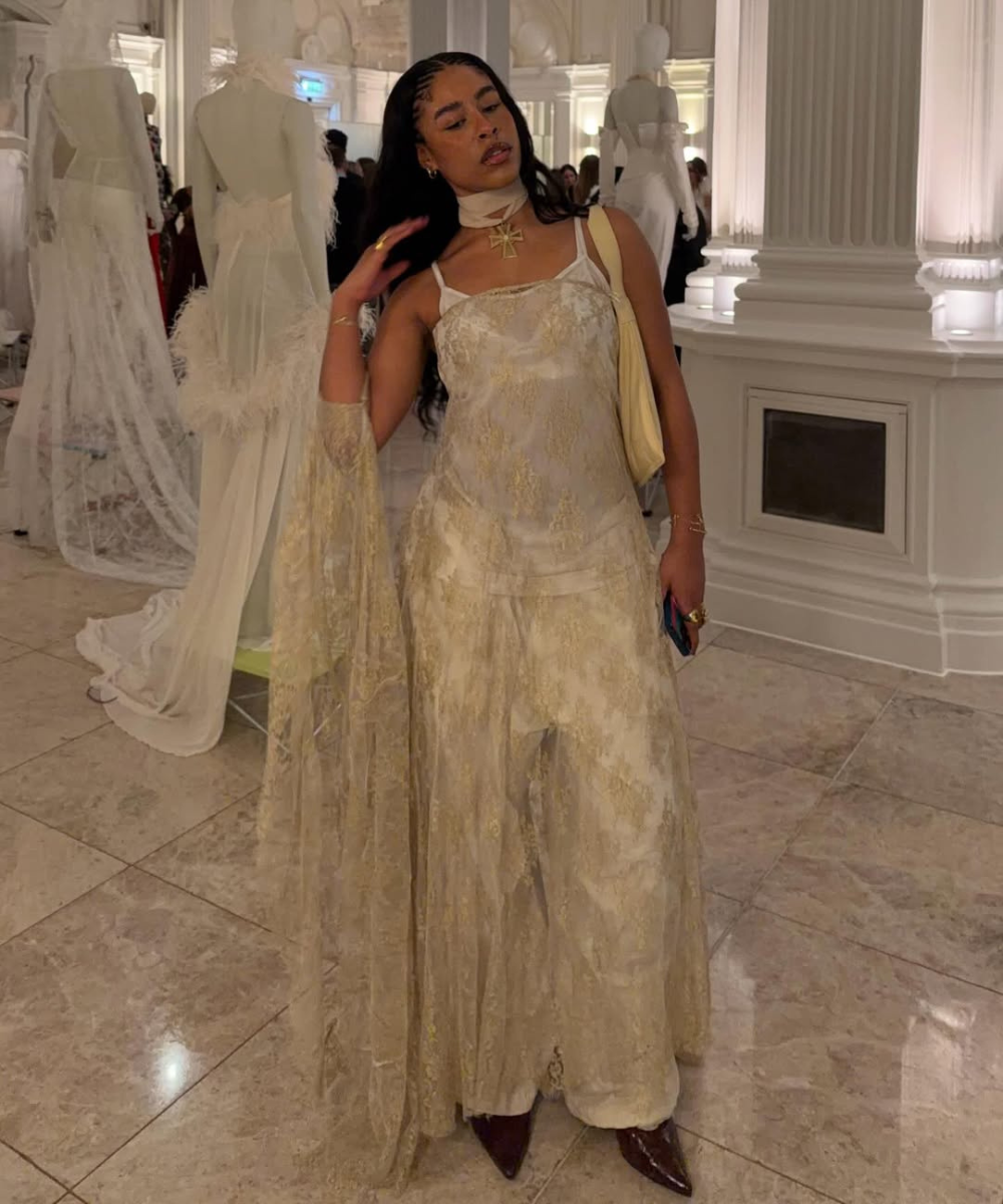 Modelo posa com lenço com pingente, vestido longo rendado bege e clima elegante em salão clássico branco