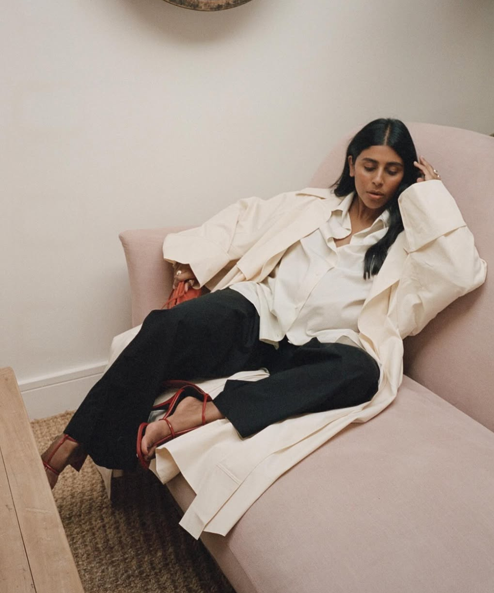 Looks de trabalho para usar durante a gravidez com camisa e trench off-white amplos, calça preta e sandália vermelha, clima