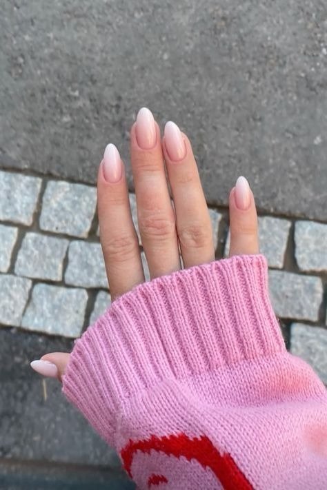 Unhas para madrinha de casamento em rosa leitoso com formato amendoado, mão posa com malha rosa canelada em clima delicado