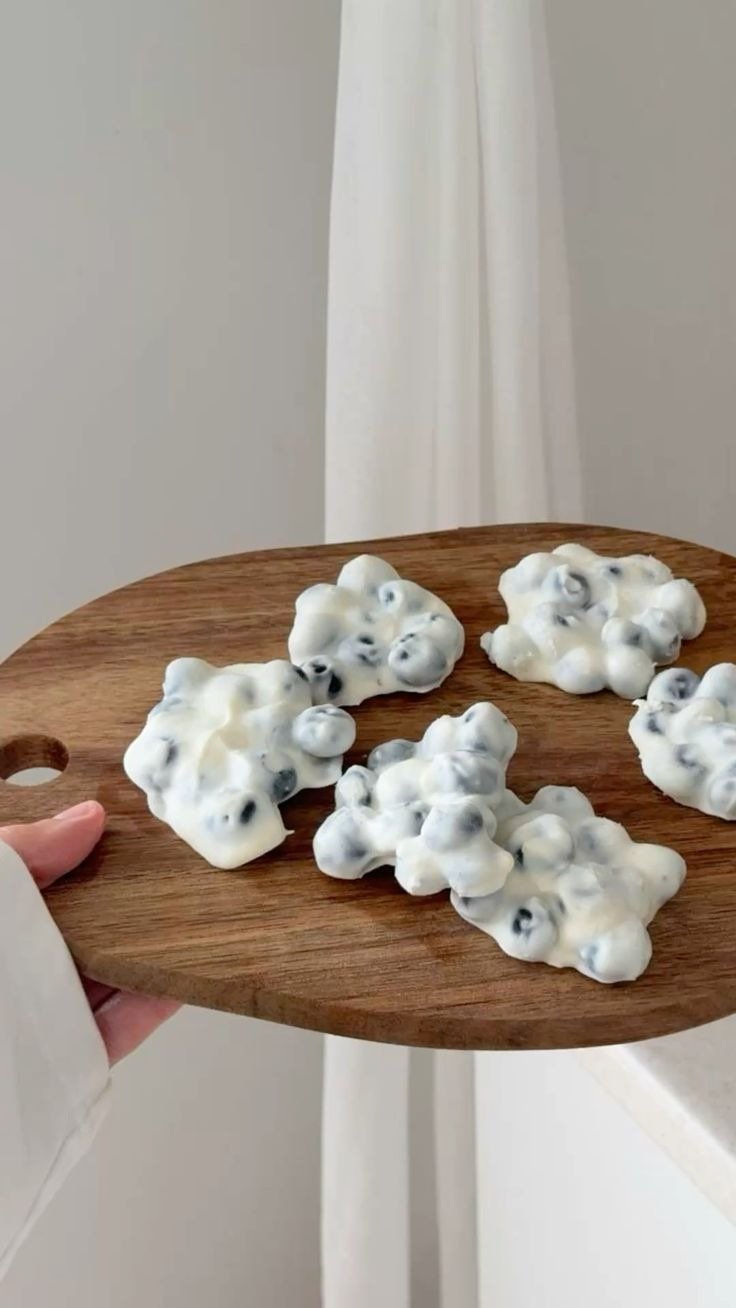 Receitas com iogurte em porções cremosas com mirtilos sobre tábua de madeira, tons neutros e clima caseiro leve