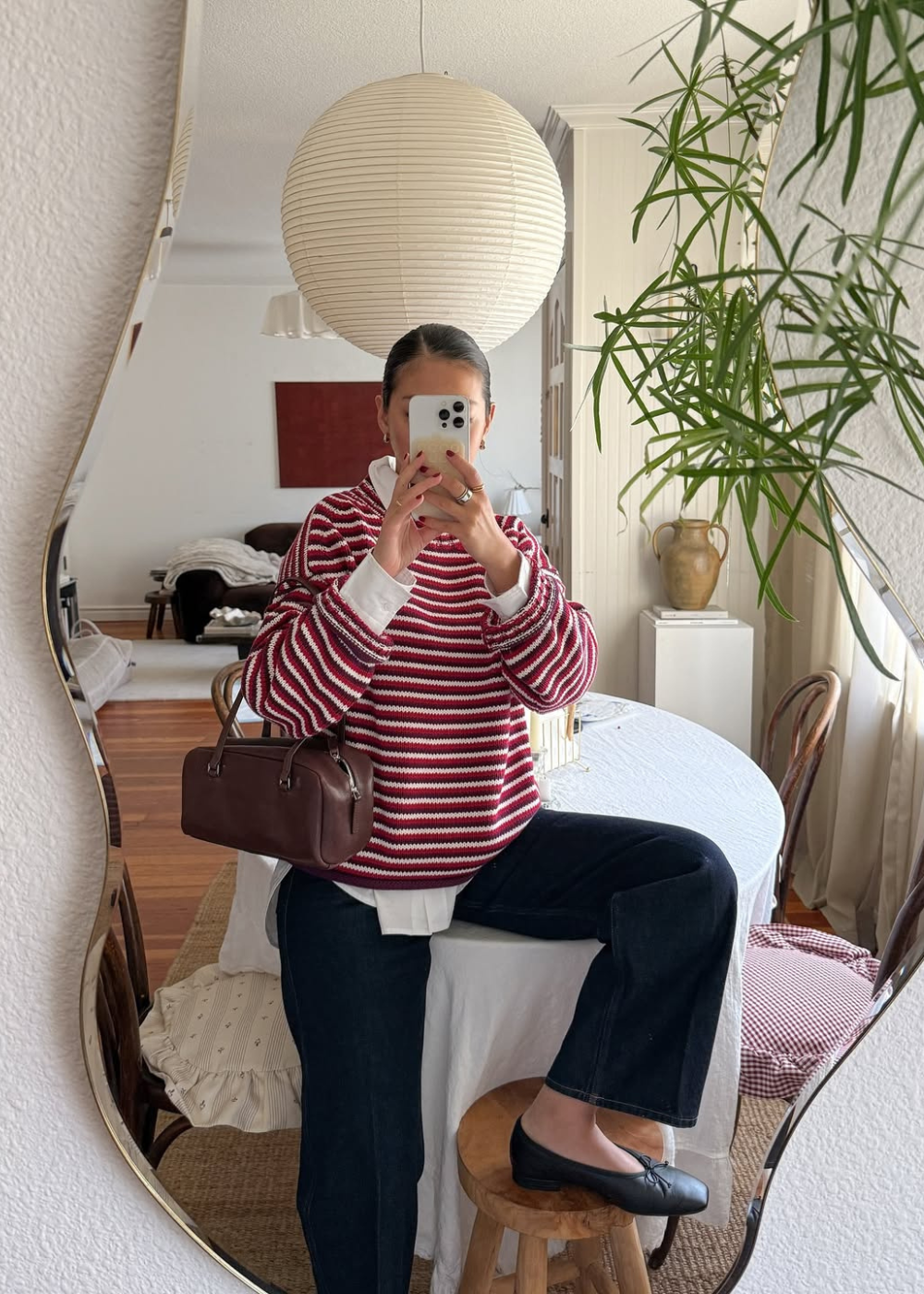 Sapatos do inverno 2026 com sapatilha preta, tricô listrado vinho e branco, jeans amplo e clima acolhedor em espelho interno.