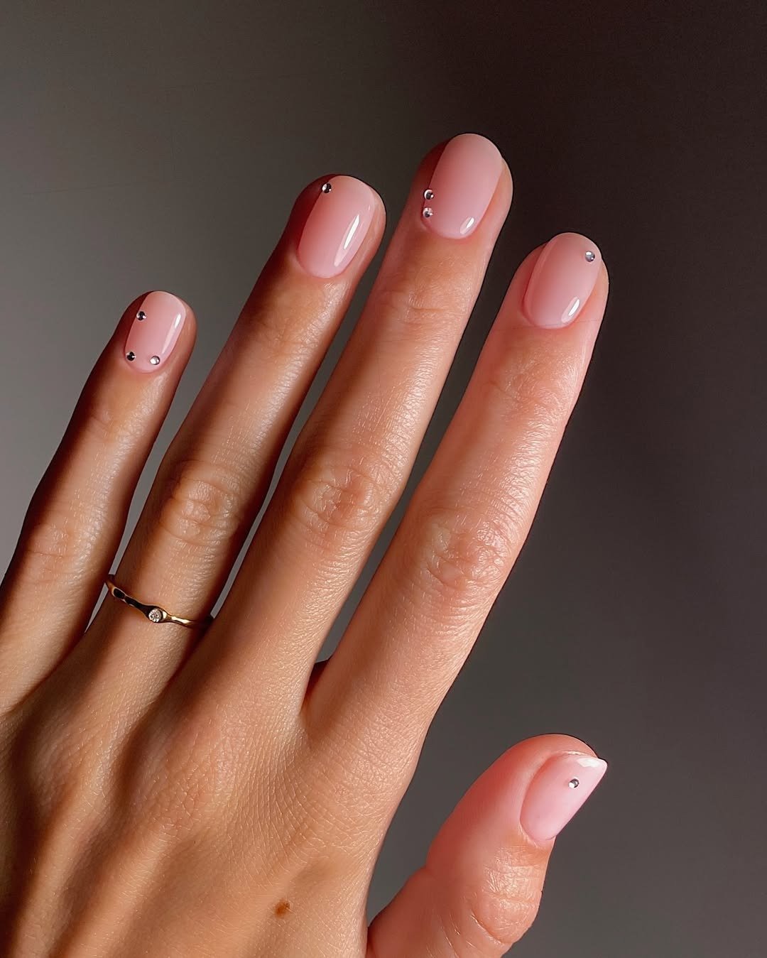 Unhas para madrinha de casamento em rosa leitoso brilhante com strass delicados e anel fino dourado, elegância suave.
