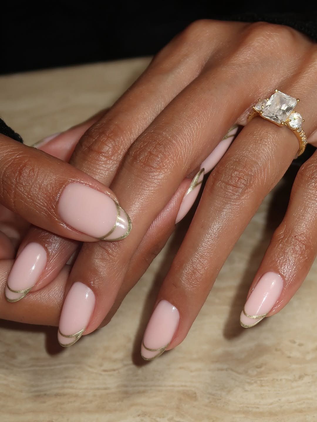 Unhas para madrinha de casamento em rosa leitoso com pontas douradas finas e anel dourado criam elegância delicada.