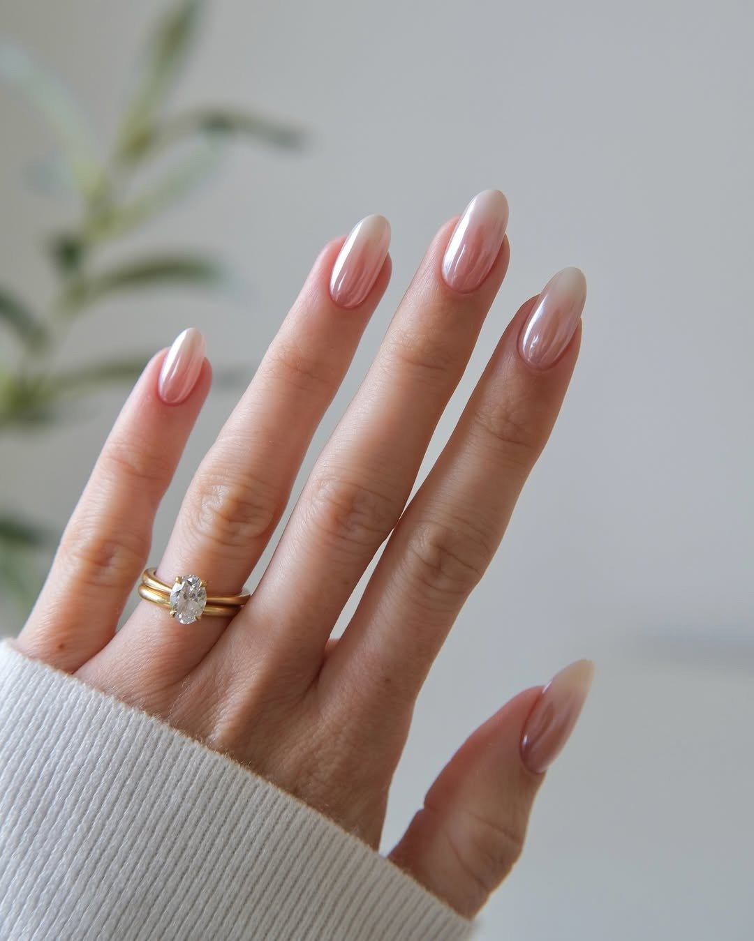 Unhas para madrinha de casamento em rosa leitoso perolado, formato amendoado, com anel dourado e clima elegante.