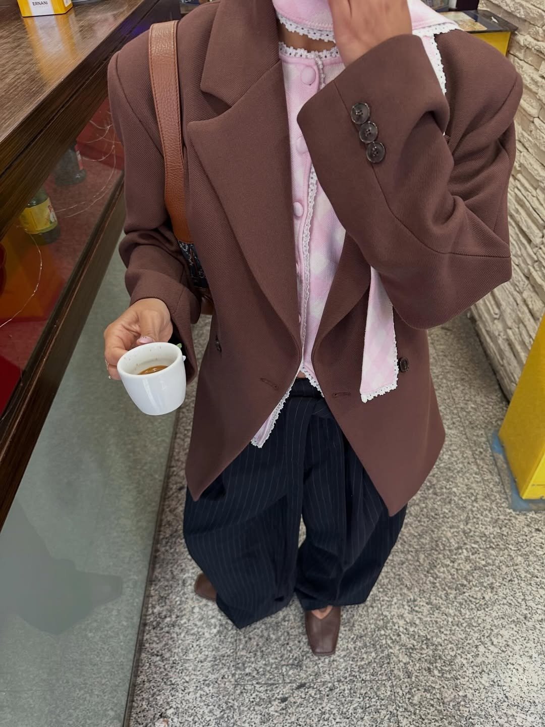 Melhores sapatos para o outono com bico quadrado marrom, blazer amplo e camisa rosa rendada em clima acolhedor