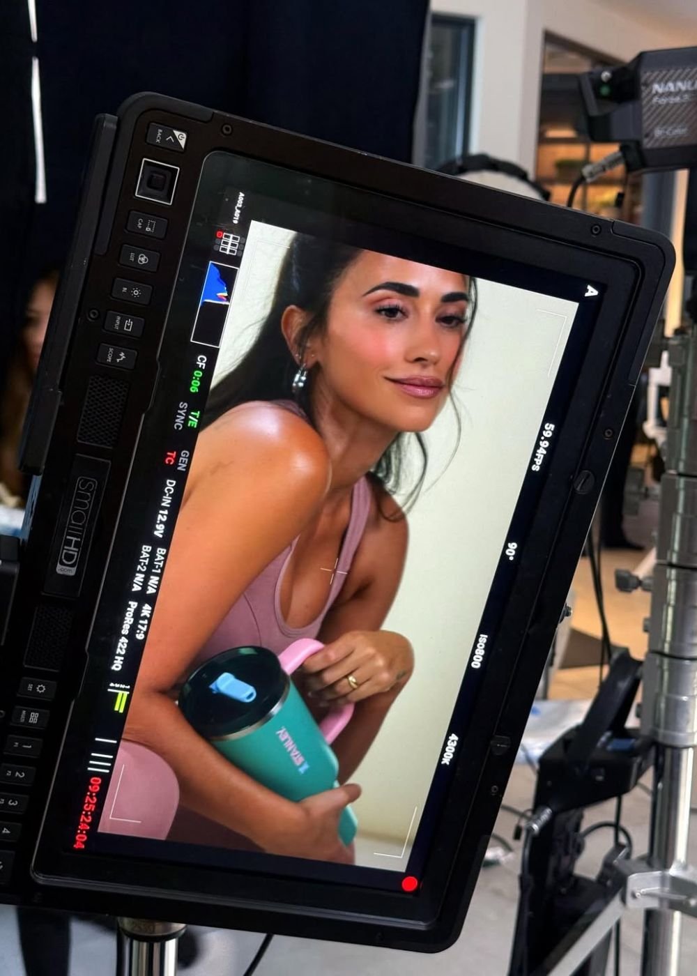 Modelo posa em set com top rosa e garrafa térmica verde, clima leve e glamouroso; Texto: STANLEY